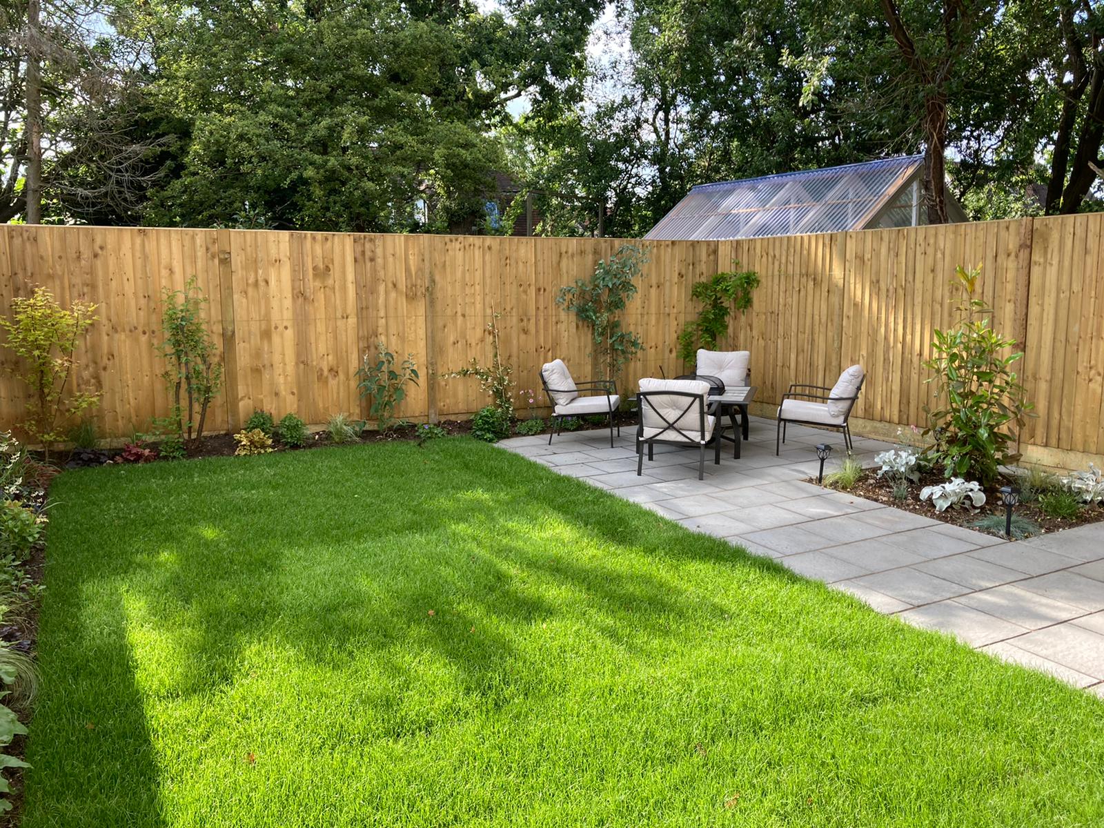Garden with new fencing, a paved seating area and a fresh lawn