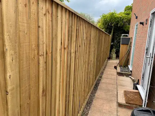 Closeboard fence running beside a paved patio