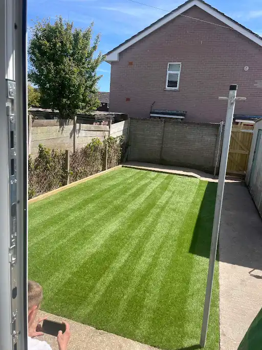 Striped artificial lawn in an enclosed garden