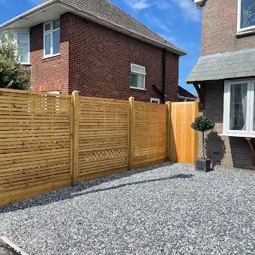 Slatted fence with a trellis top in front of a house
