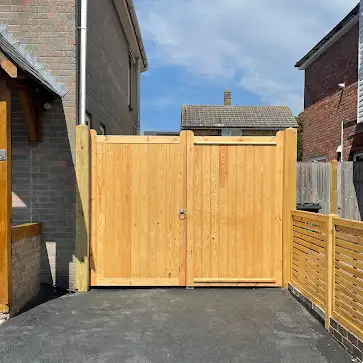 Solid timber gate beside a slatted panel